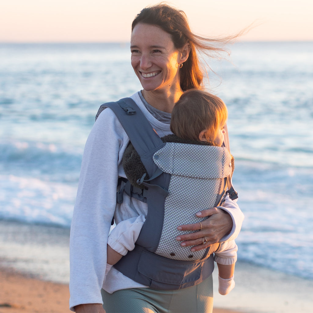 Baby in a front carry grey Beco 8 baby carrier