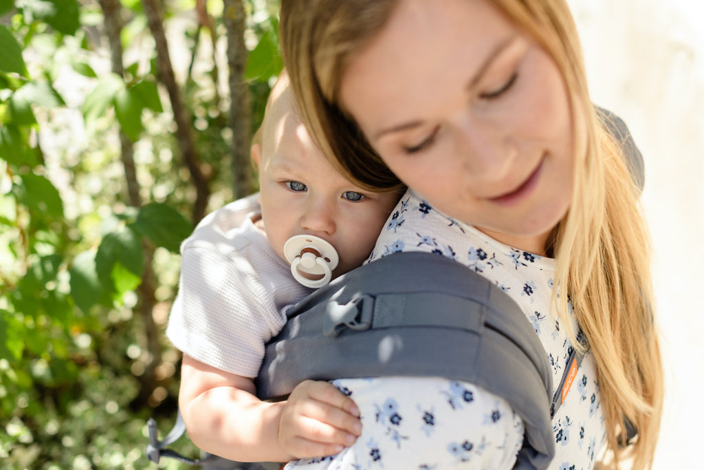 Close up of straps with baby in Beco Gemini back carry position
