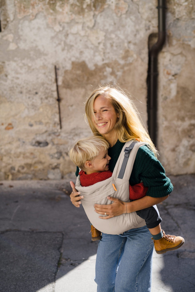 Beco Toddler Carrier in ecru, shown with toddler in the front carry position