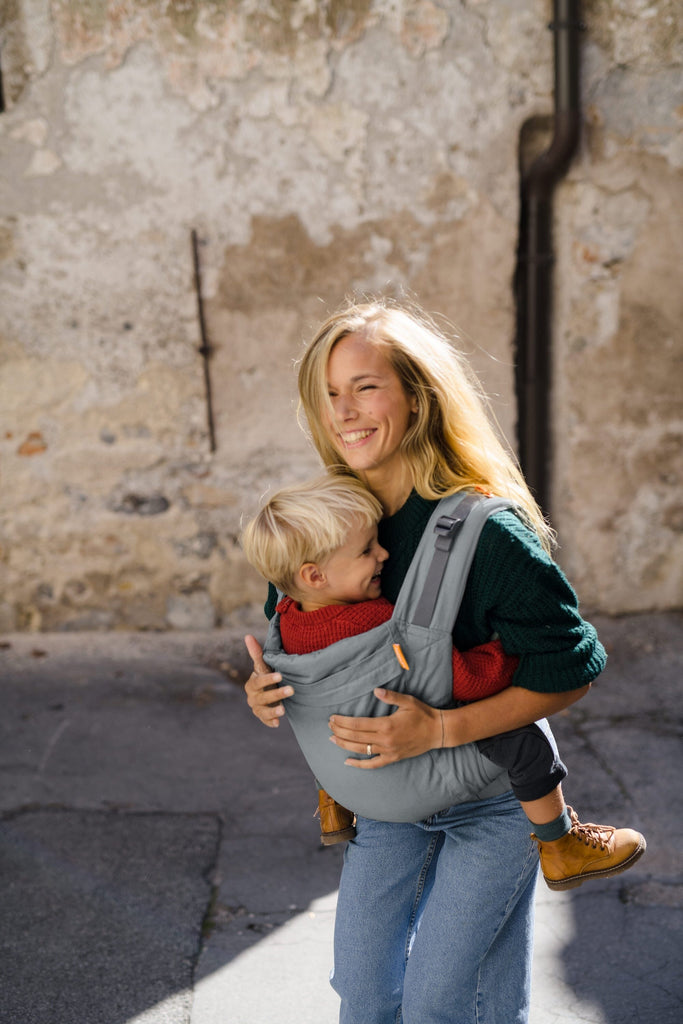 Beco Toddler Carrier in grey, shown with toddler in the front carry position