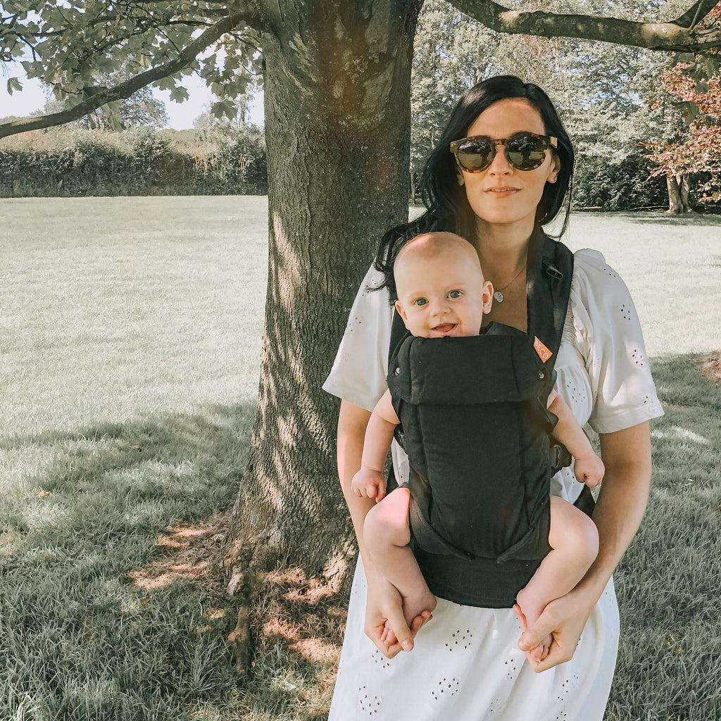 Baby in a front worn black Beco baby carrier