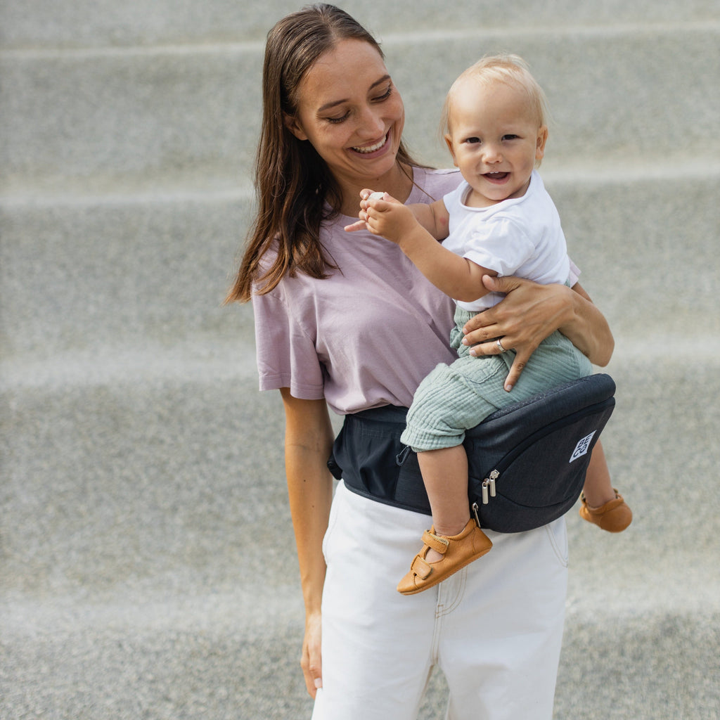 Beco Gemini Hip Seat Baby Carrier in black, ergonomic design for newborns to toddlers, featuring 4 carry positions and even weight distribution for all-day comfort.