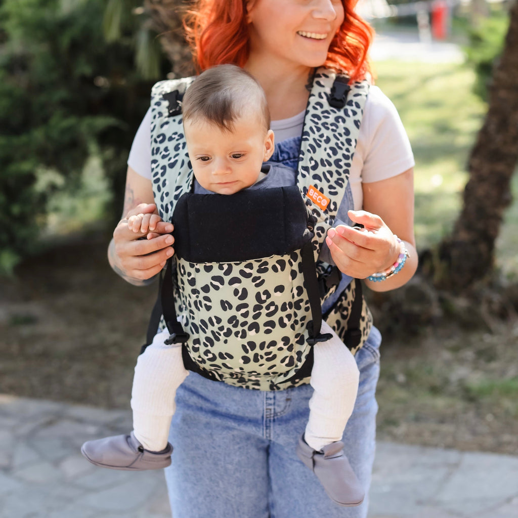 Baby facing out in the Beco Gemini baby carrier in jade leopard pattern
