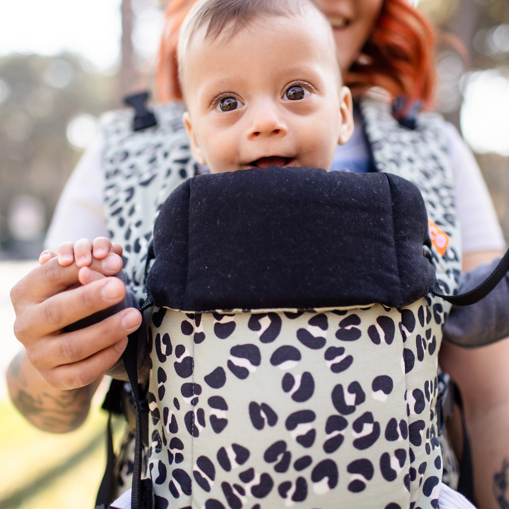 Close up of the a baby in the Beco Gemini baby carrier in jade leopard pattern
